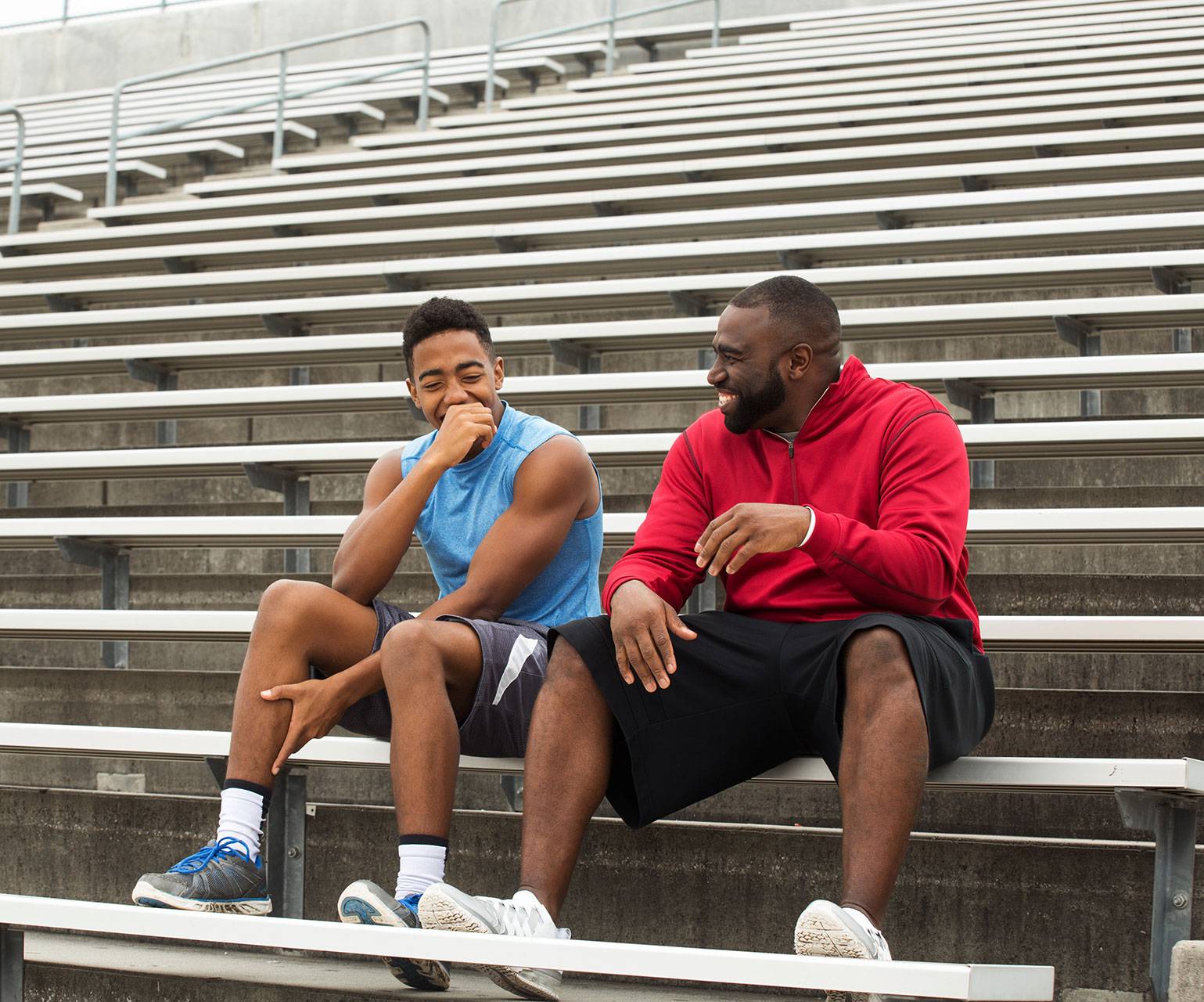 coach sitting with athlete in college stadium